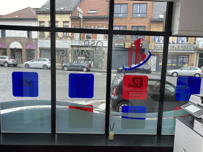 Logo et texte bilingues appliqués en vitrophanie sur la façade vitrée d'un bureau.