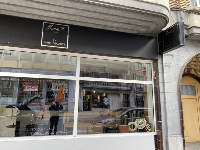 Enseigne noire et lettrage sur vitrine pour une agence de décoration et d'aménagement.