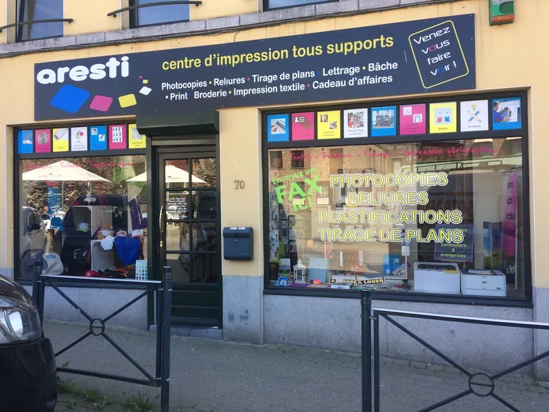Enseigne colorée et fenêtres décorées de visuels pour un centre d'impression tous supports.