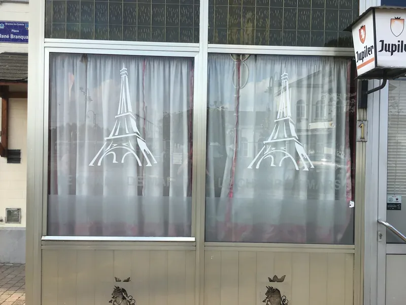 Motif de tour Eiffel découpé en vitrophanie blanche sur la vitrine givrée d'un restaurant.