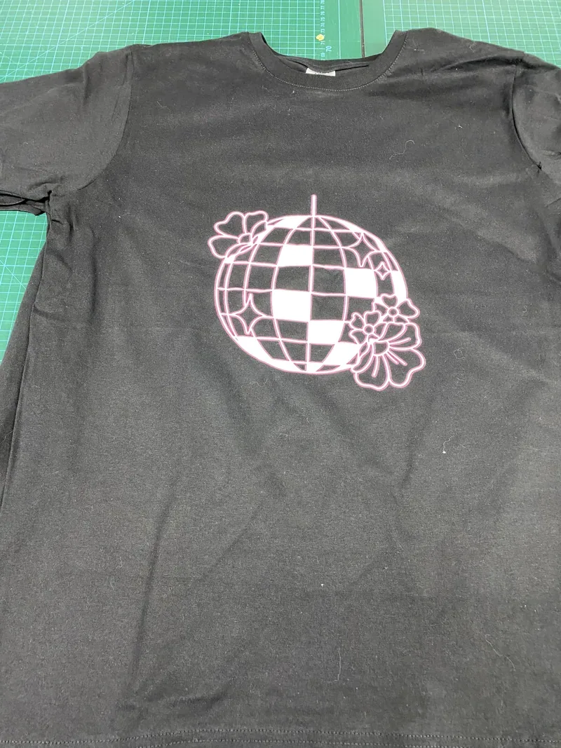 T-shirt noir avec impression fluo rose d'une boule à facettes fleurie.