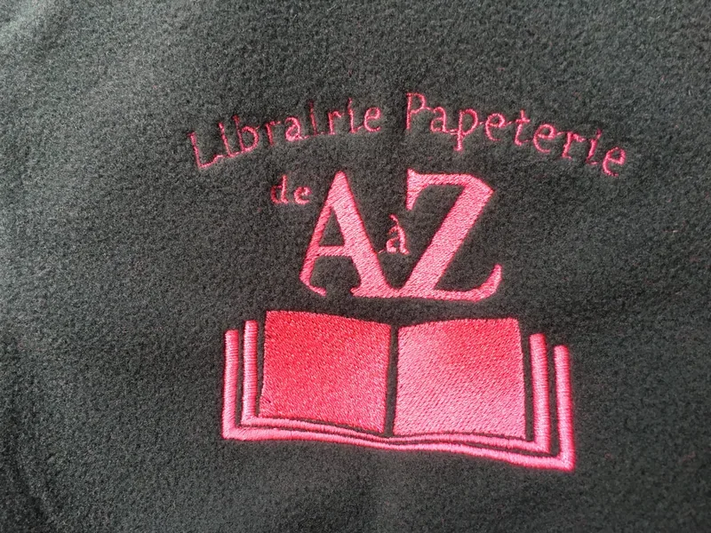 Broderie rose détaillée sur une polaire noire.