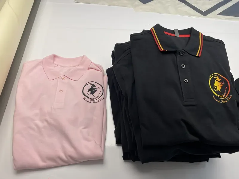 Polos rose et noir floqués du blason du Comité des Fêtes de Lonzée.