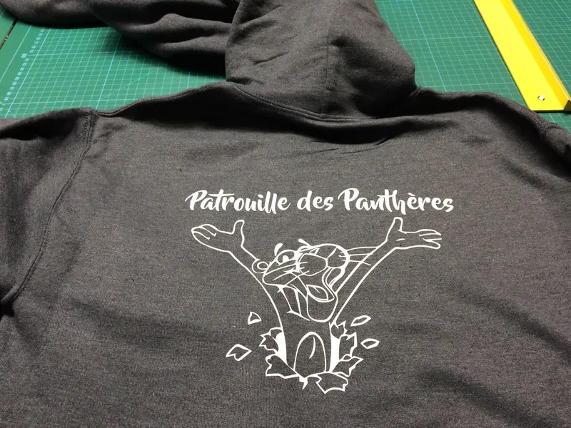 Sweat anthracite floqué en blanc d'une panthère bondissante et de son nom.
