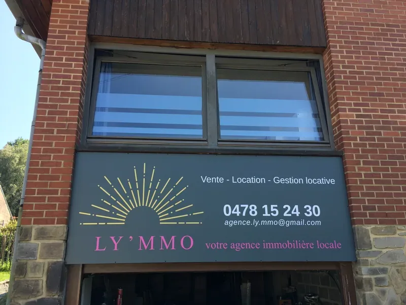 Panneau publicitaire LY'MMO fixé en façade, lettrage clair et couleurs vives lisibles.
