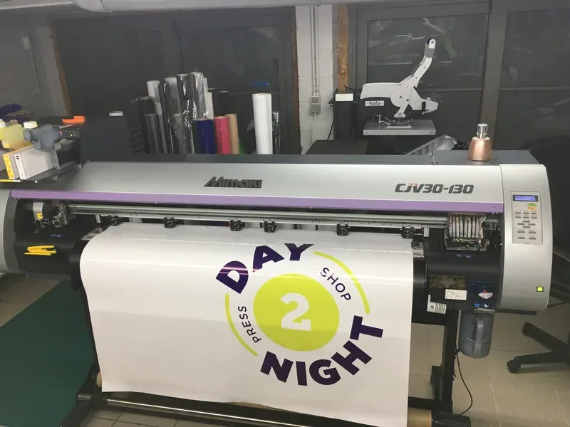 Traceur d'impression numérique produisant un autocollant rond pour une boutique, à l'atelier.